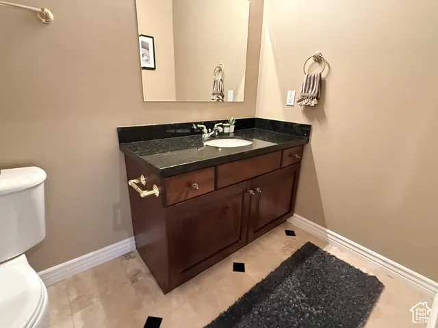 Wood-finish vanity with a dark countertop and integrated sink