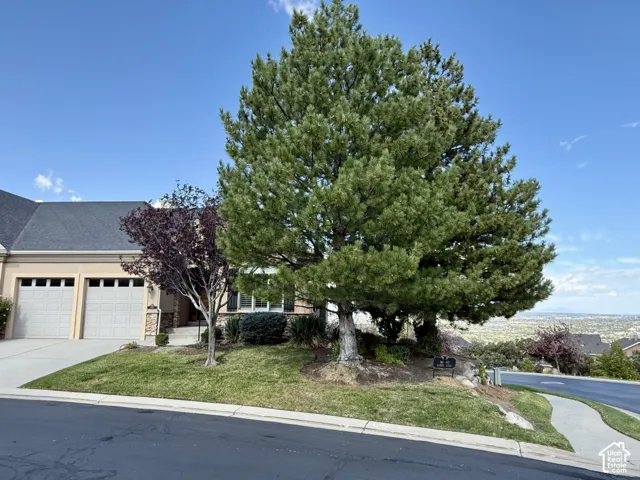 Stucco exterior with a dark shingle roof, attached two-car garage, and a concrete driveway