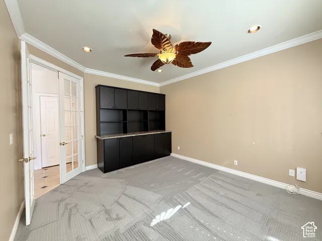 Room featuring built-in dark cabinetry with a light-toned countertop, recessed lighting, and a ceiling fan with decorative blades