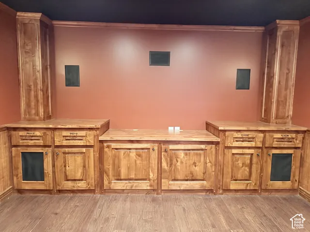 Custom built-in cabinetry with wood-finish doors and drawers, integrated wall speakers, and recessed lighting
