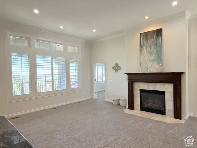 Spacious living area featuring a central fireplace with a dark wood mantel and light-toned tile surround