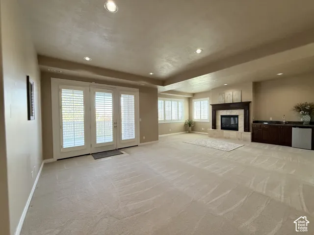 Spacious room featuring light-toned carpeting and recessed lighting