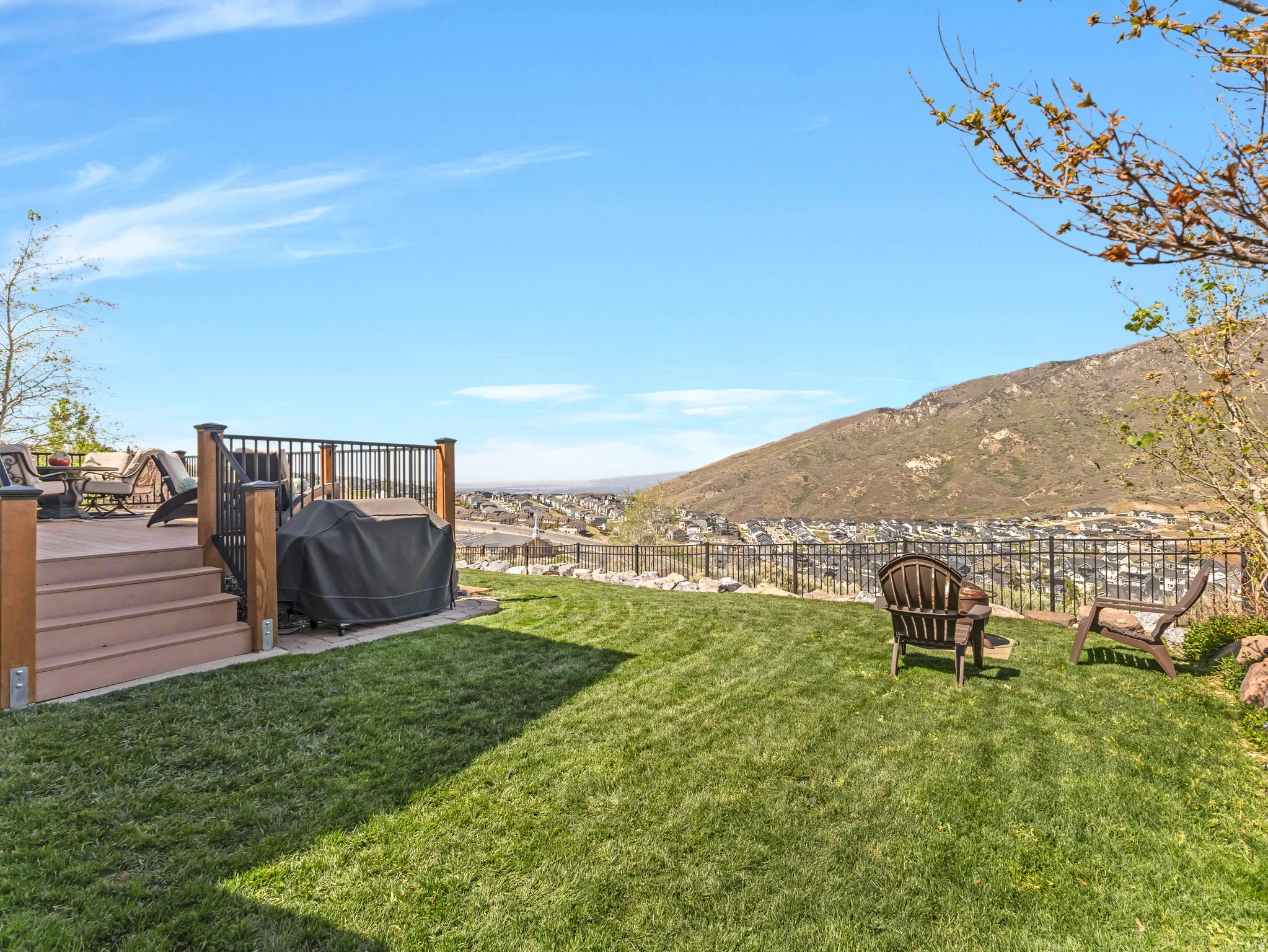 Expansive tiered backyard featuring a manicured lawn and a multi-level composite deck