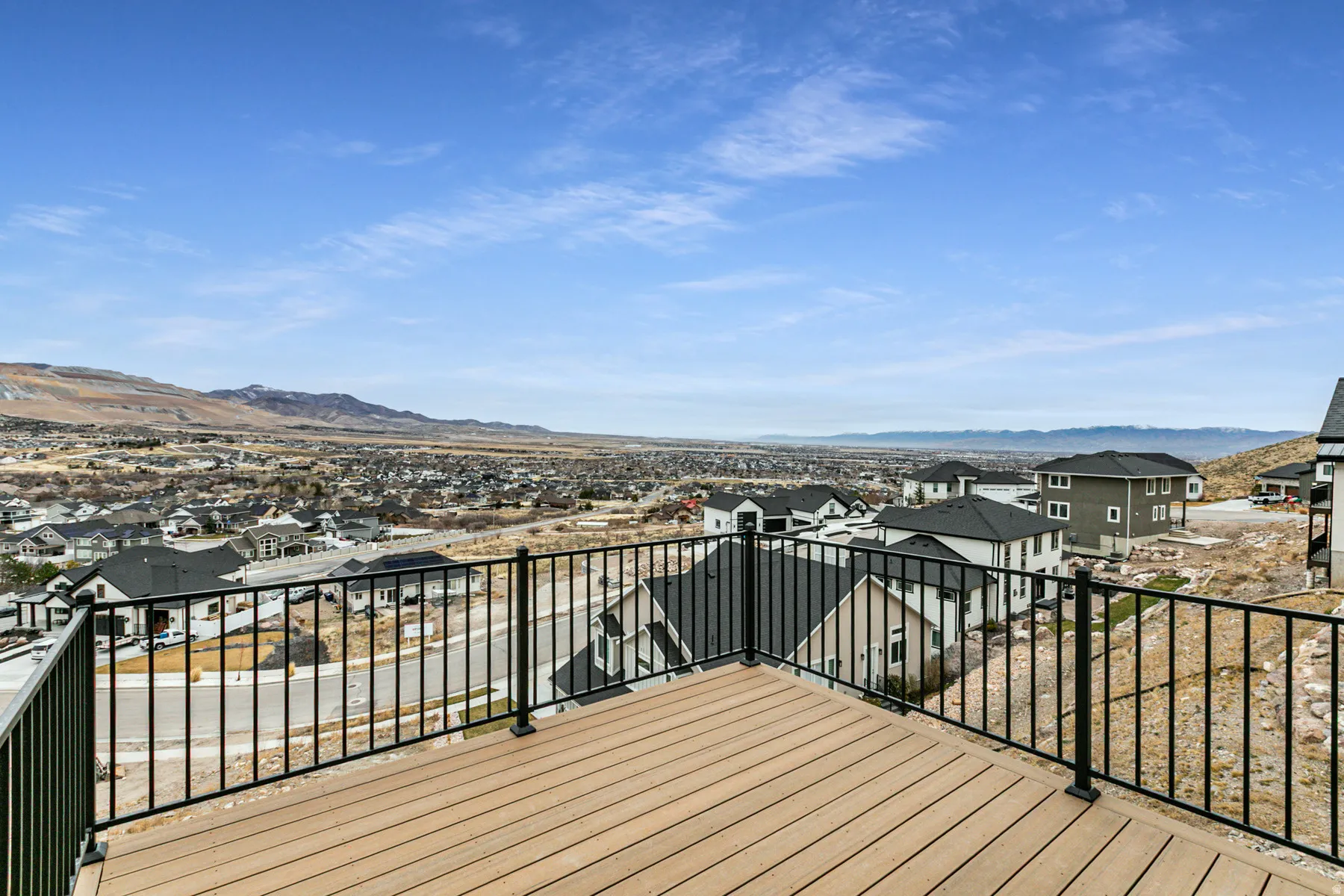 Expansive outdoor deck featuring wood-finish flooring and black metal railings