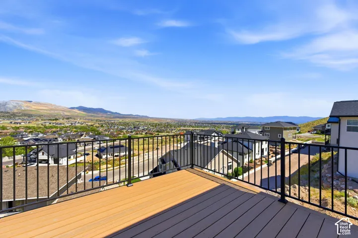 Expansive outdoor deck featuring wood-finish flooring and black metal railings