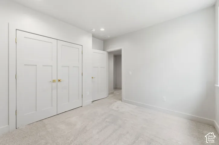 Bright interior space featuring light gray carpeting and white walls