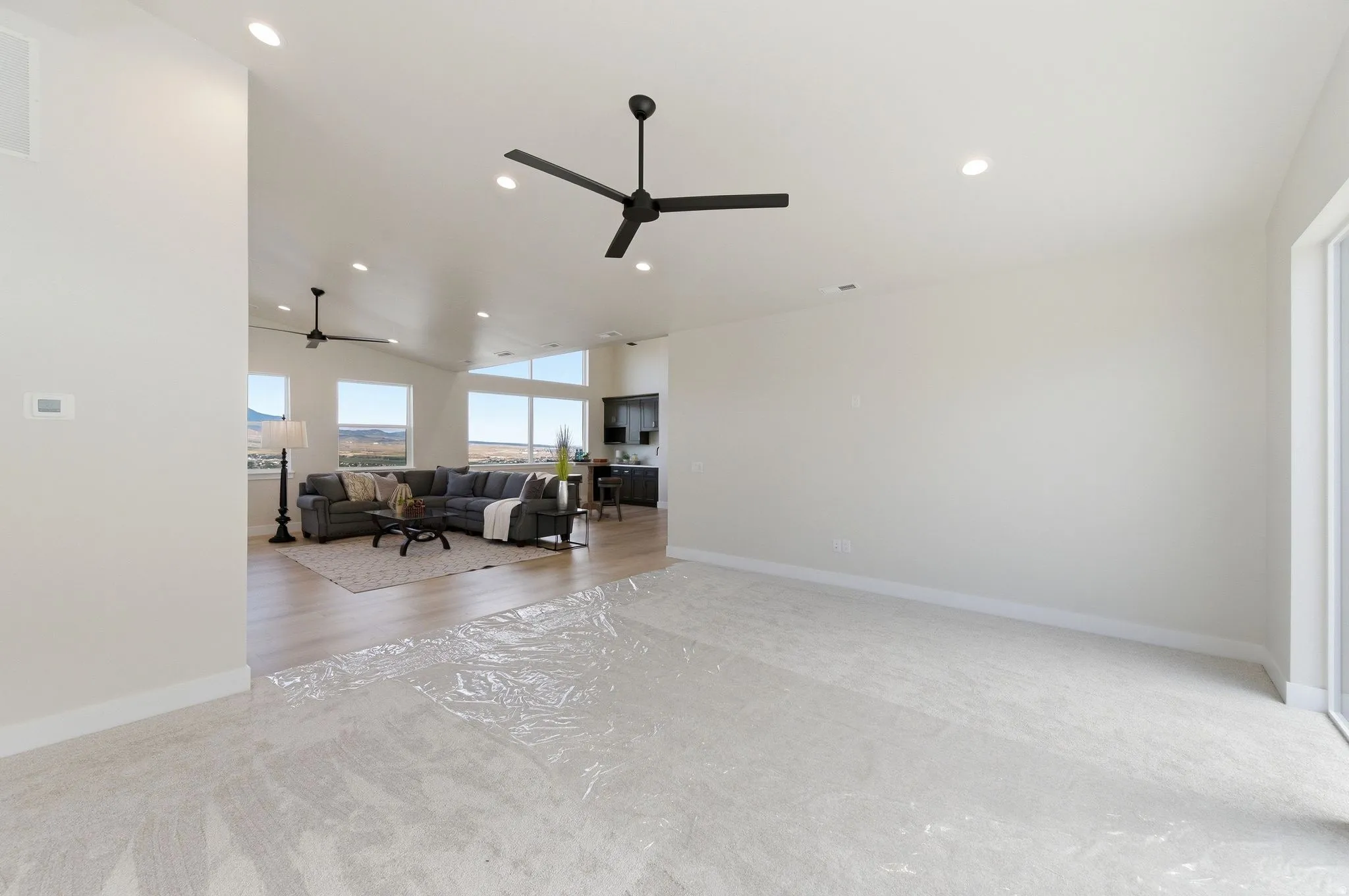 Open-concept living space featuring high ceilings, recessed lighting, and multiple large windows