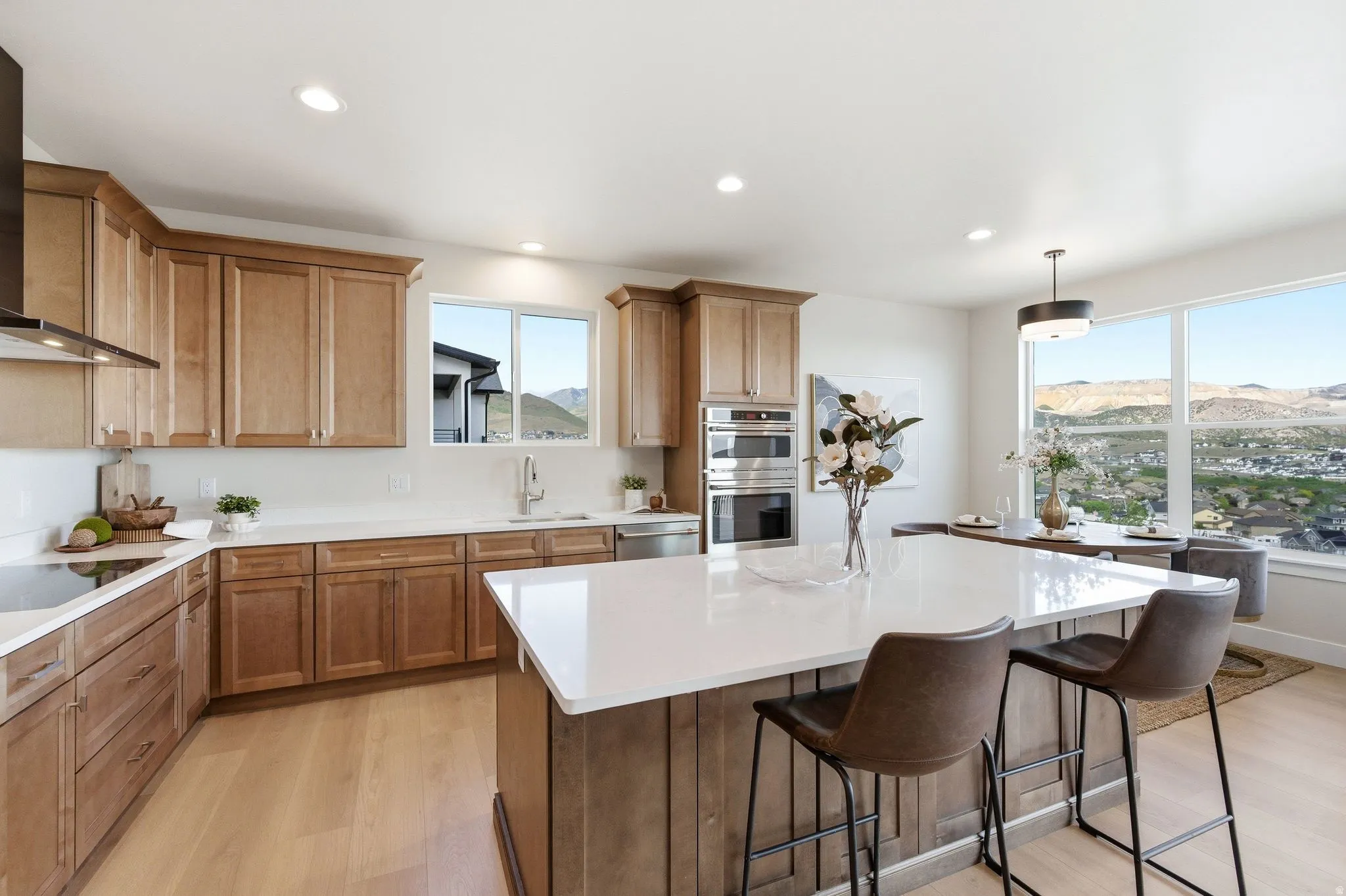 Spacious kitchen featuring light wood-finish cabinetry, white countertops, and a large central island