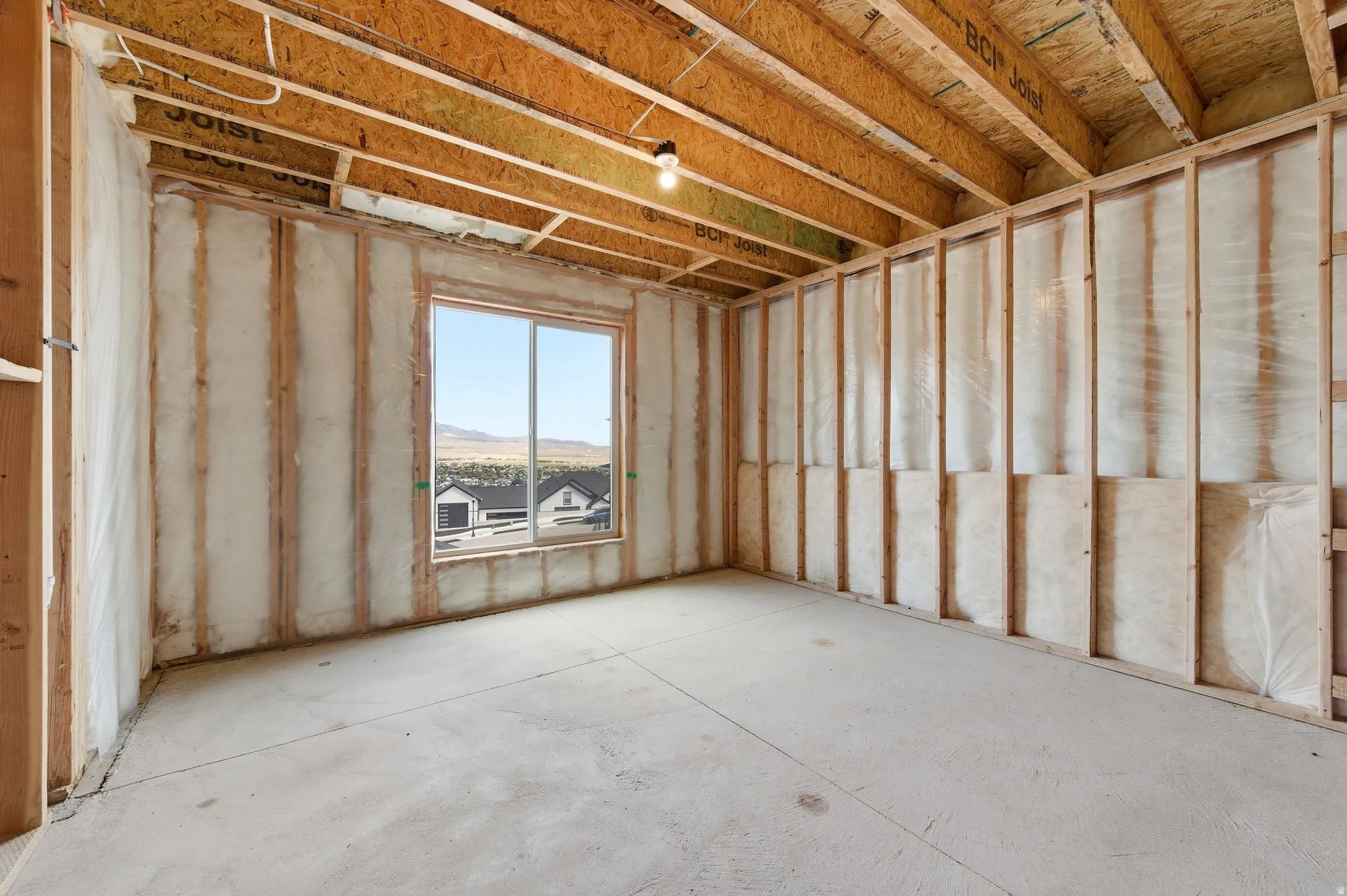 Unfinished interior space featuring exposed wood framing, ceiling joists, and wall insulation