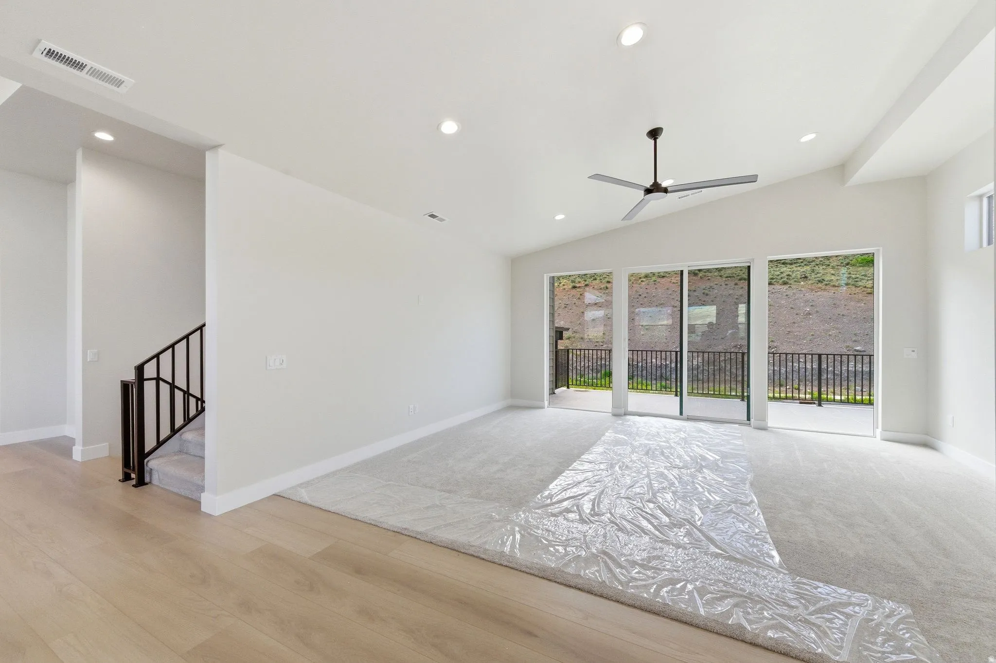 Bright living area featuring a vaulted ceiling and recessed lighting
