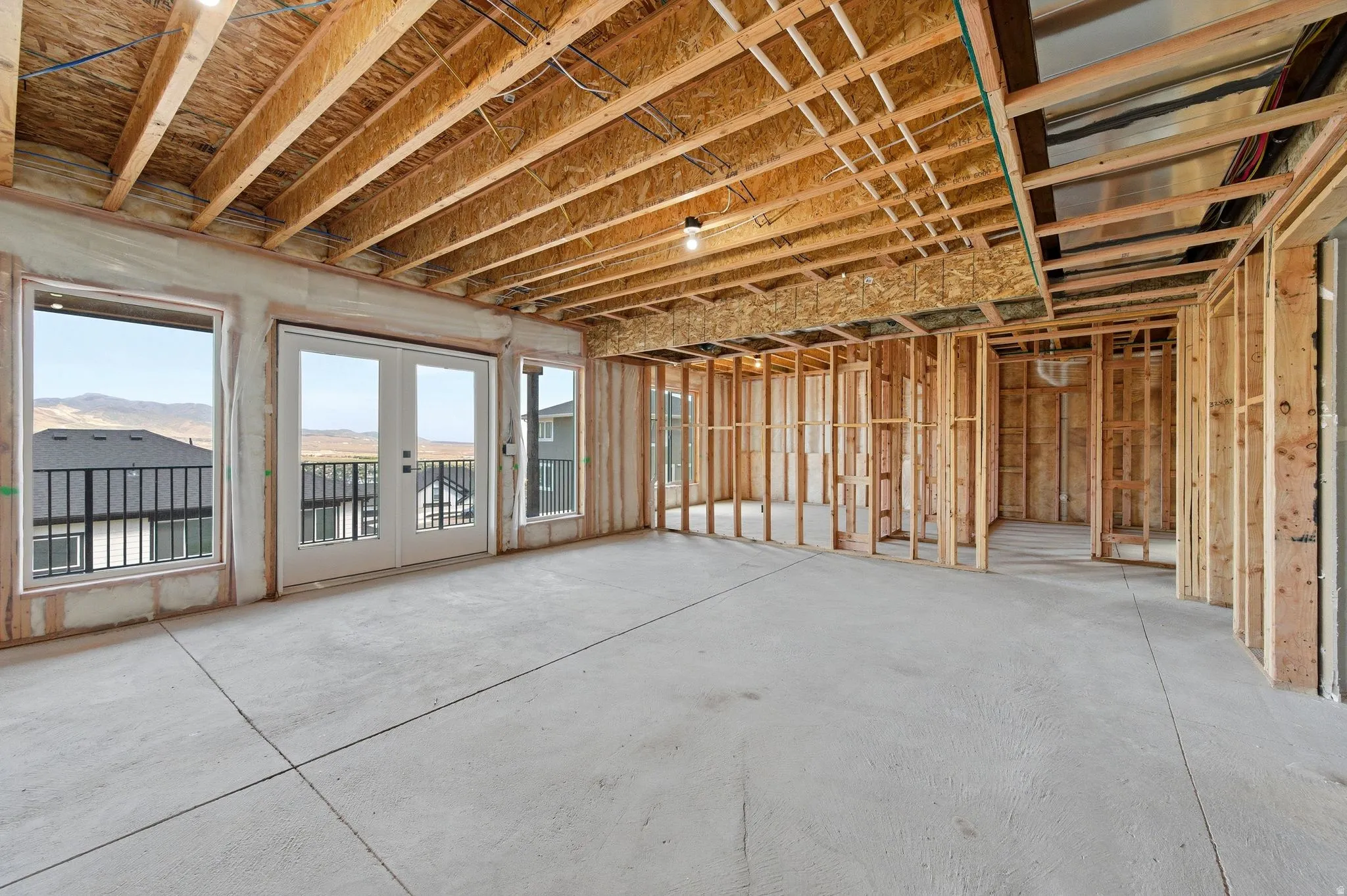 Unfinished interior space featuring exposed wood framing, concrete flooring, and an exposed wood joist ceiling