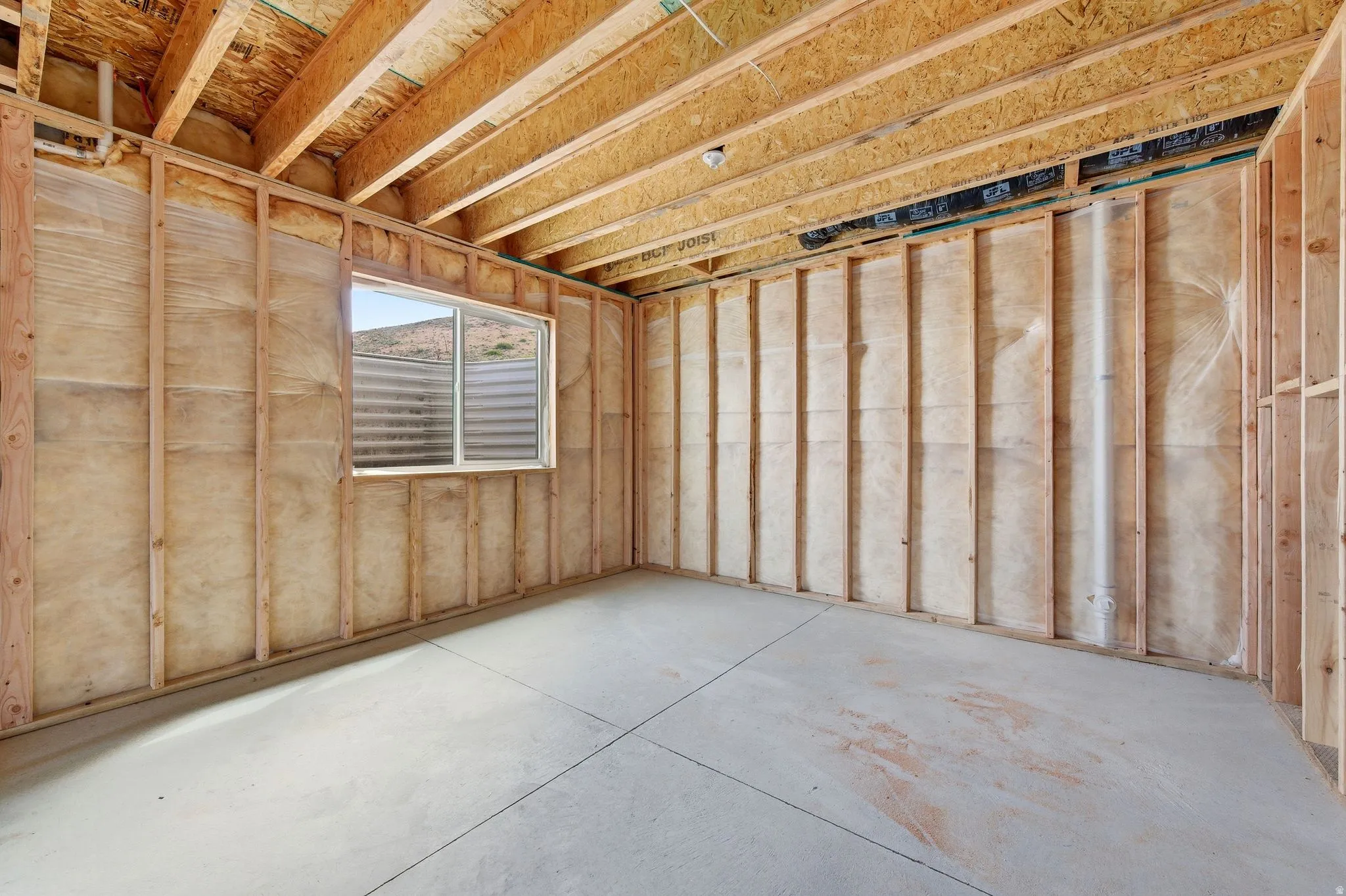 Framed interior space with exposed ceiling joists and subfloor