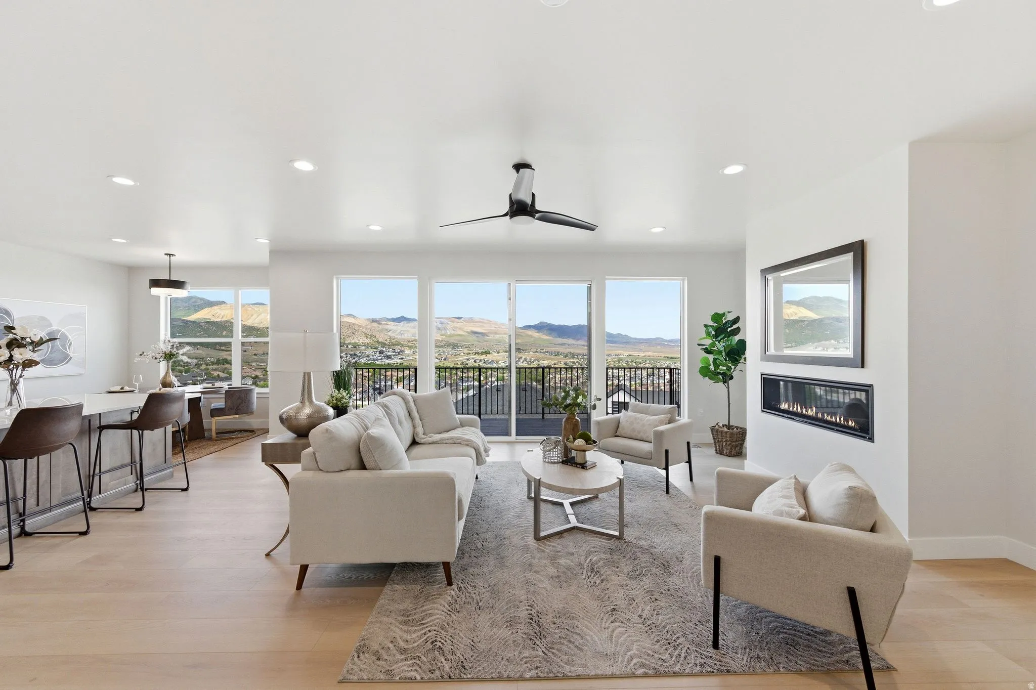Open-concept living space featuring wood-finish flooring, a linear fireplace, and recessed lighting