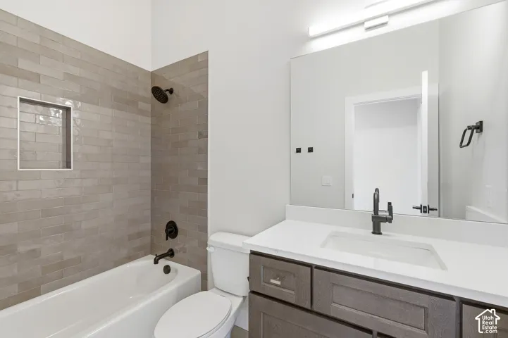 Bathroom featuring an integrated tub with subway tile surround, matte black fixtures, and a recessed shower niche