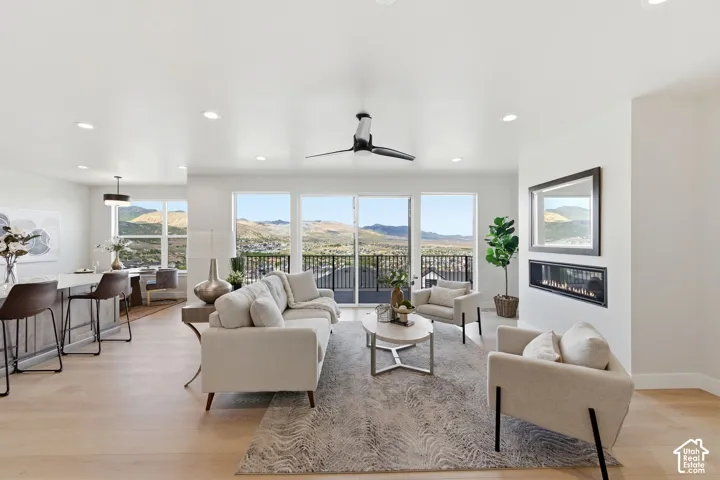 Open-concept living space featuring wood-finish flooring, a linear fireplace, and recessed lighting