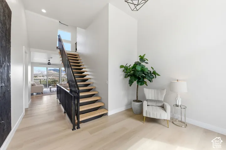 Floating staircase with light wood treads and black metal railing