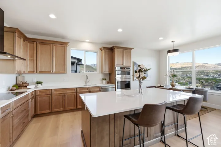 Spacious kitchen featuring light wood-finish cabinetry, white countertops, and a large central island