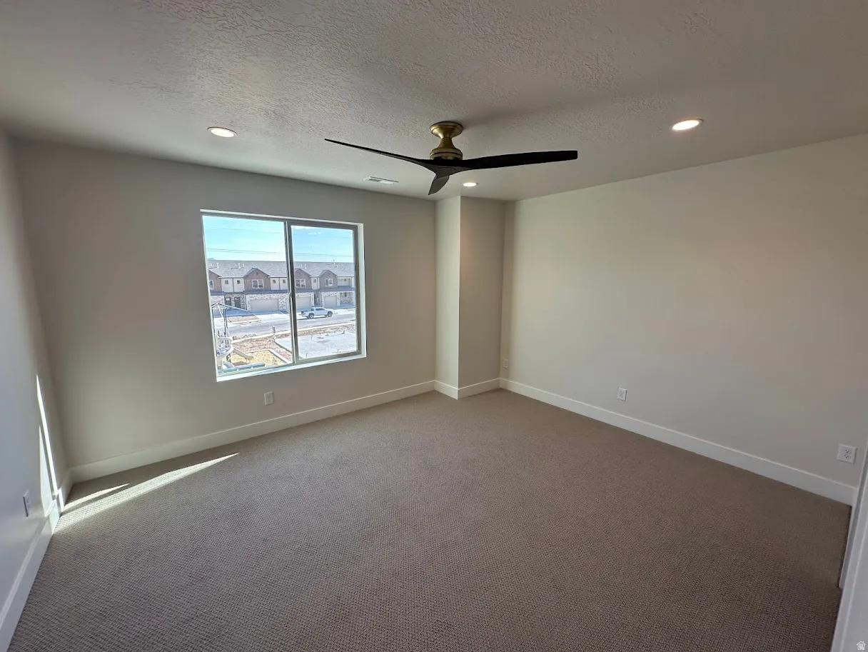 Spacious room featuring neutral carpeting and light-colored walls