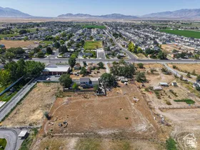Expansive lot with cleared land, bordered by paved roads and established residential properties