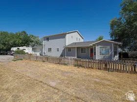 Two-story residence with light gray siding and a contrasting red entry door