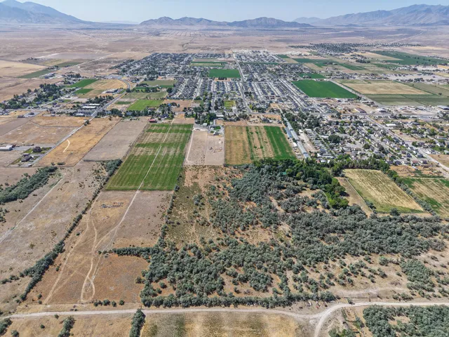 Expansive aerial view showcasing a landscape characterized by open fields, cultivated land, and natural vegetation