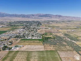 Expansive land parcel featuring a mix of agricultural fields and undeveloped natural terrain