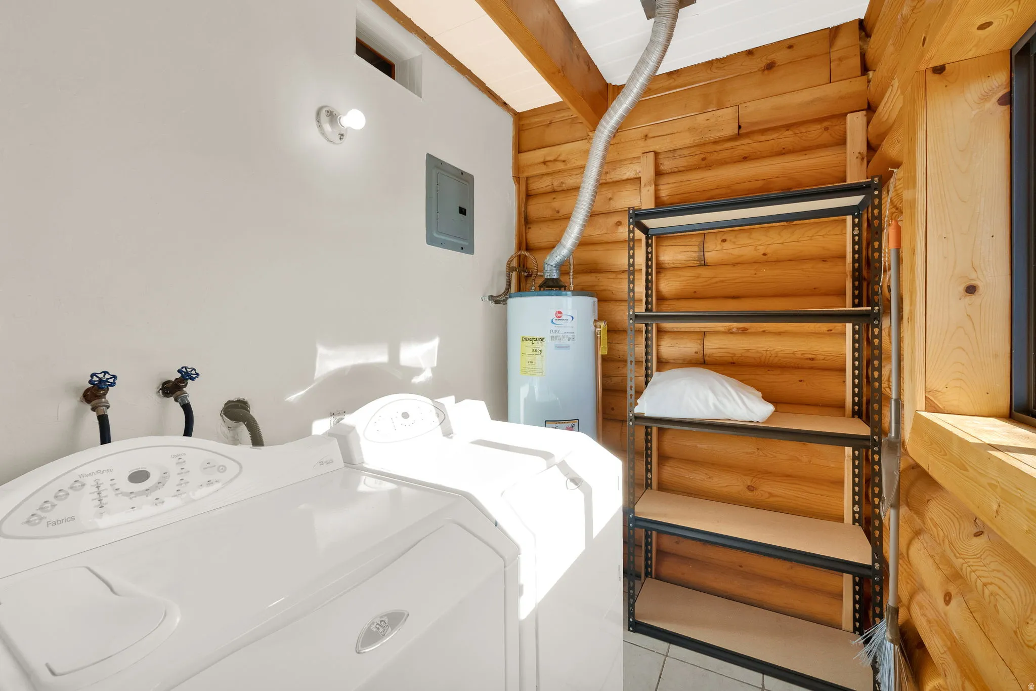 Utility area featuring a top-load washing machine, a water heater, built-in shelving, and exposed wood walls