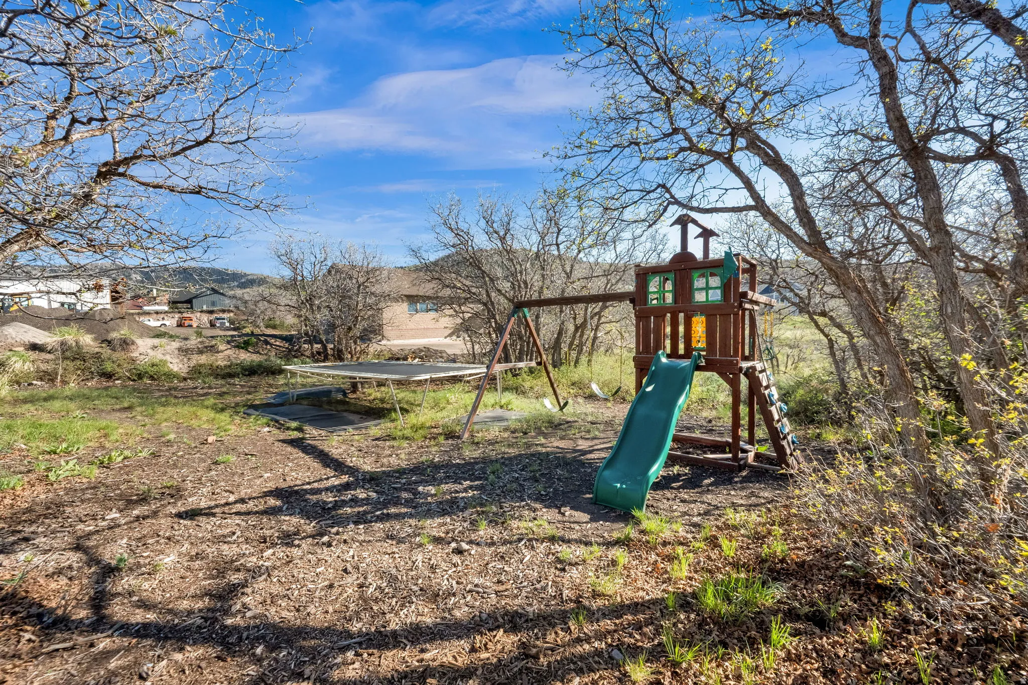 Expansive outdoor space featuring mature trees and established ground cover