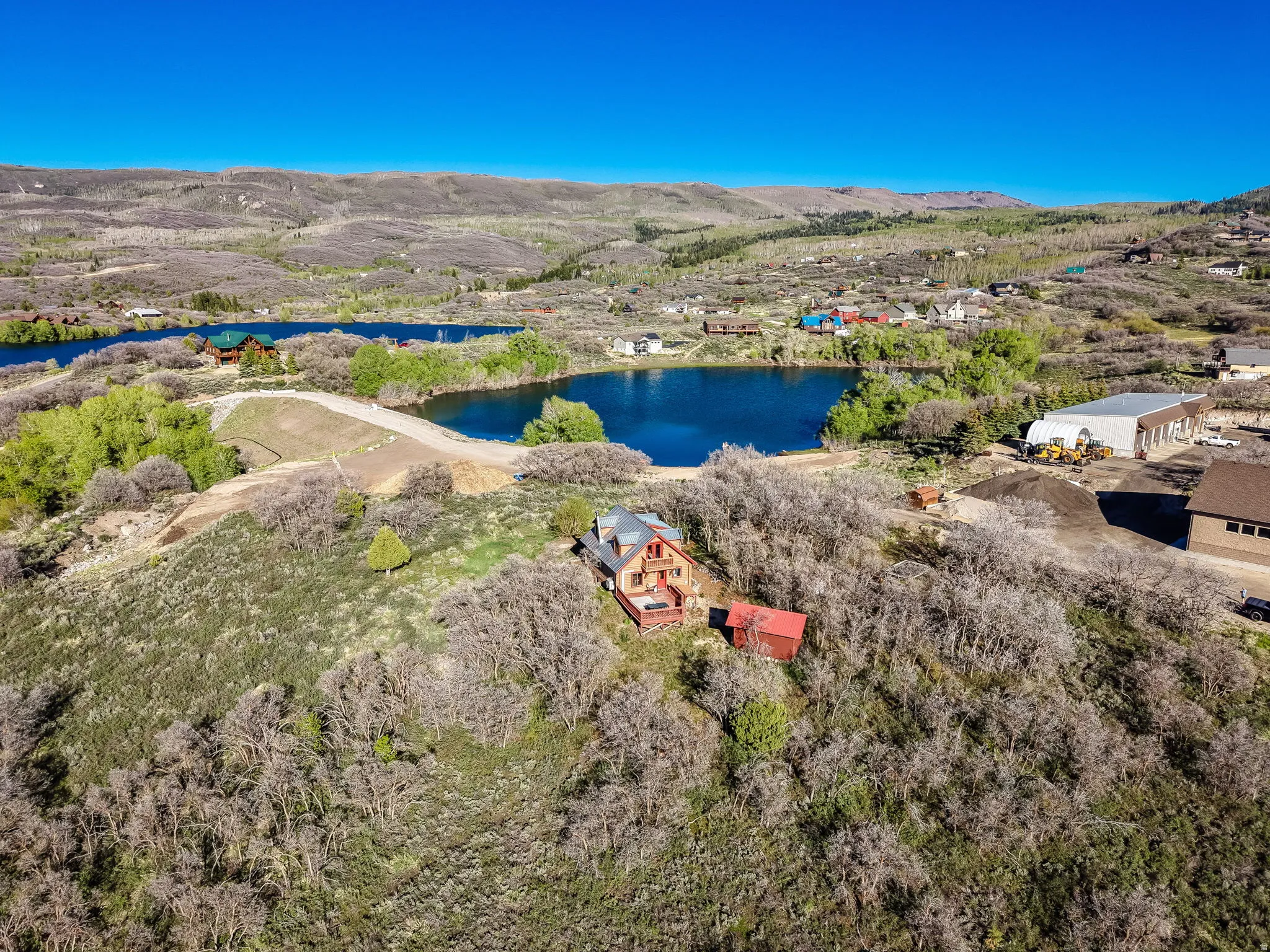 Cabin-style dwelling with a red metal roof and wood siding situated on a hillside