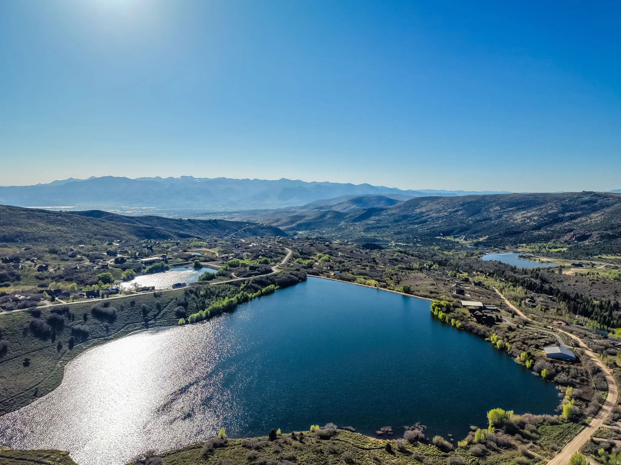 Aerial perspective showcasing a large body of water bordered by undeveloped land and sparse vegetation