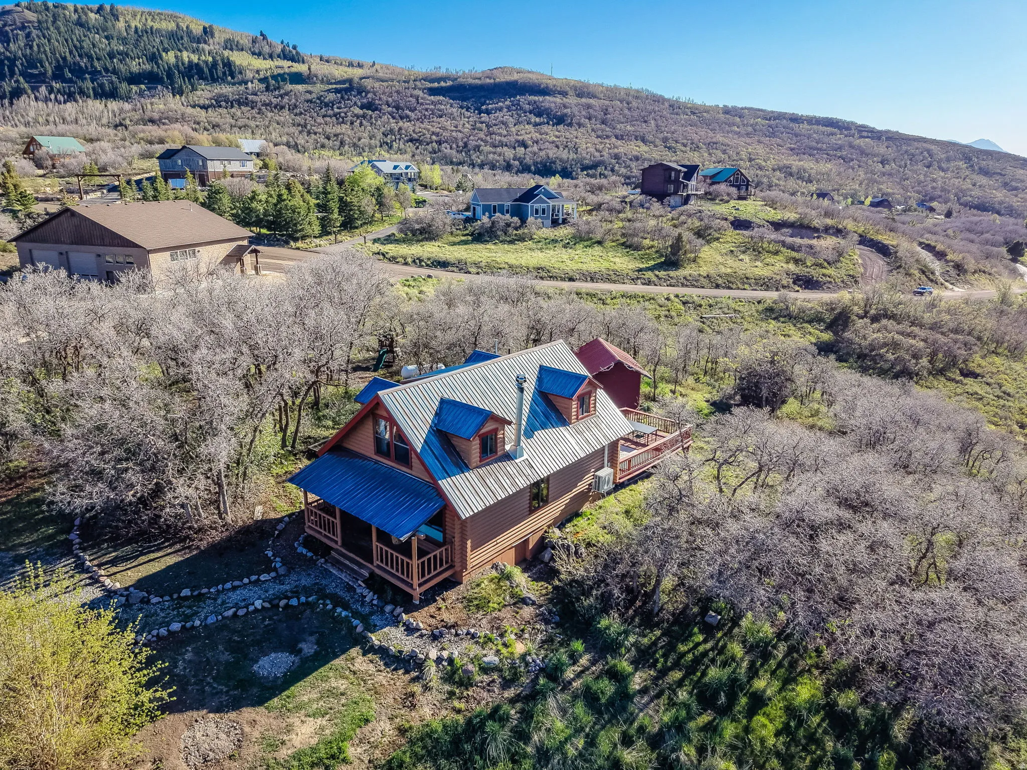 Wood-sided residence featuring a metal roof, dormer windows, and a covered front porch