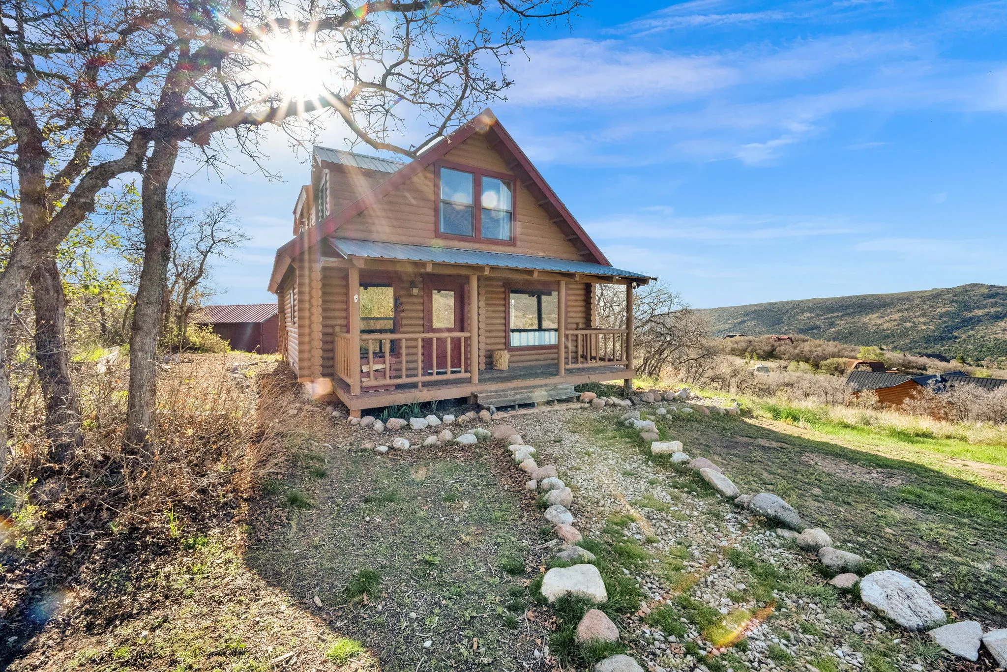 Cabin-style residence featuring natural wood siding and a covered front porch