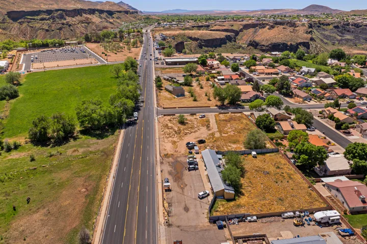 Expansive aerial view showcasing a multi-lane roadway bordered by various land parcels and residential properties