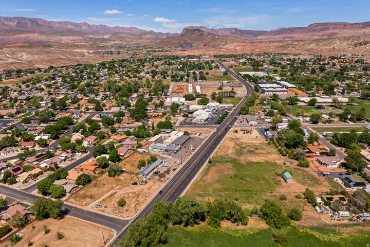 Aerial perspective showcasing a developed community with residential areas, commercial establishments, and open land parcels