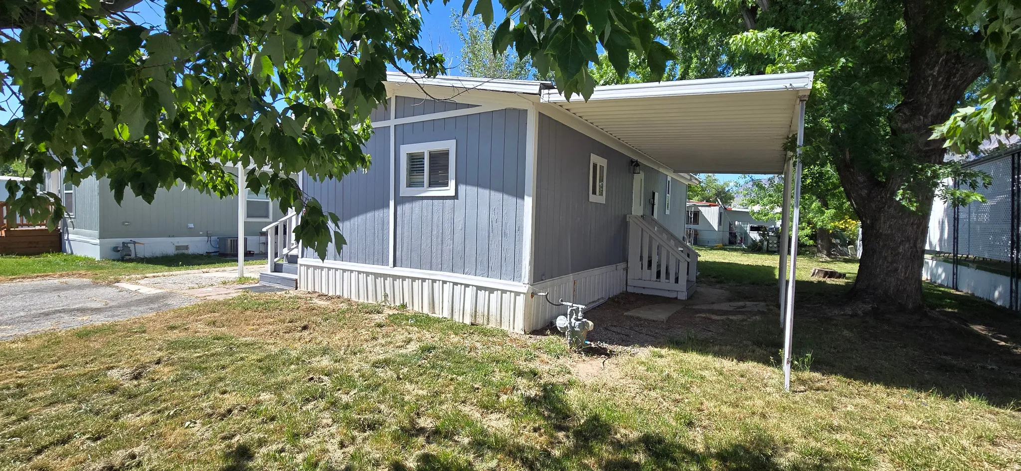 Light blue siding exterior with white trim and skirting