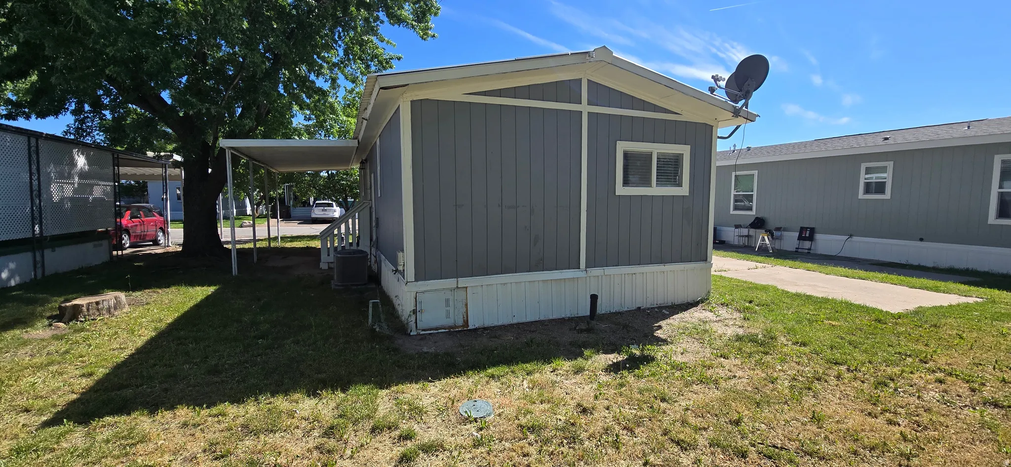 Exterior featuring gray vertical siding, white trim, and a covered side entry