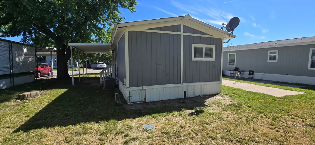 Exterior featuring gray vertical siding, white trim, and a covered side entry