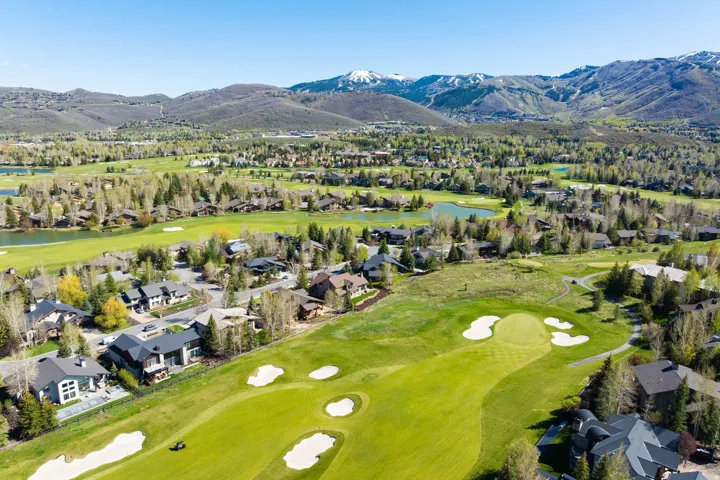 Expansive aerial view showcasing a golf course setting with sand traps and manicured greens