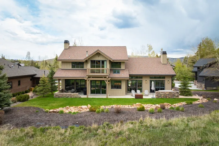 Crafted two-story residence featuring a wood-siding exterior and a pitched shingle roof