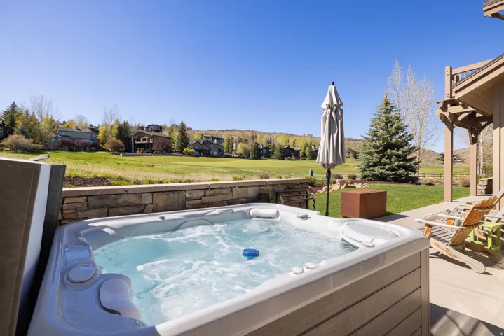 Outdoor hot tub with stone-finish surround