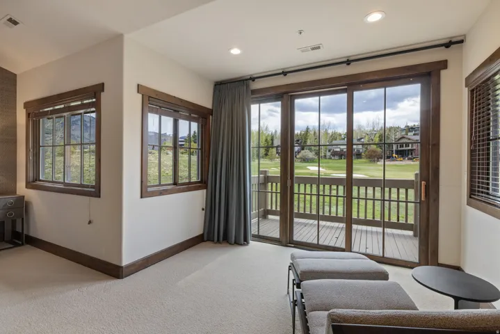 Sliding glass doors open to a deck overlooking a golf course