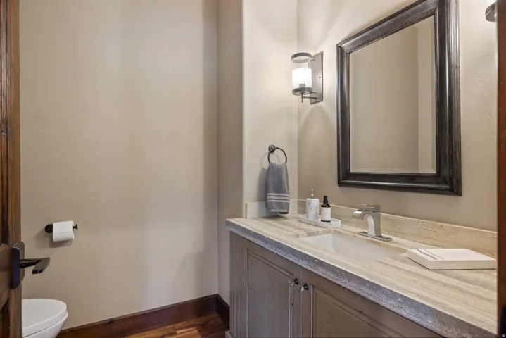 Vanity featuring a rectangular undermount sink, brushed nickel faucet, and a stone countertop