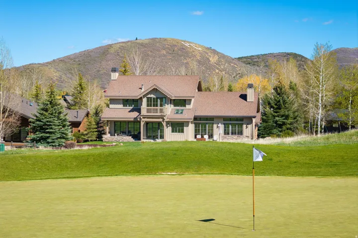Expansive golf course frontage featuring a manicured green and flagstick