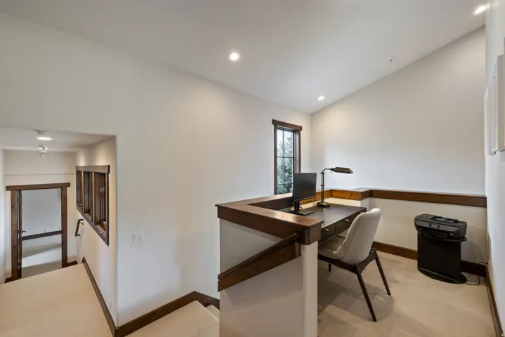 Loft area featuring a built-in wood-finish desk, recessed lighting, a framed window, and carpeted flooring
