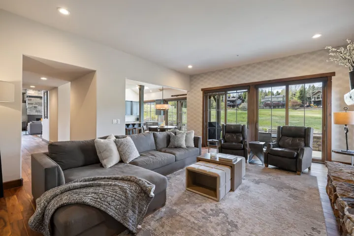 Spacious living area featuring large sliding glass doors, recessed lighting, and a stone-clad fireplace surround