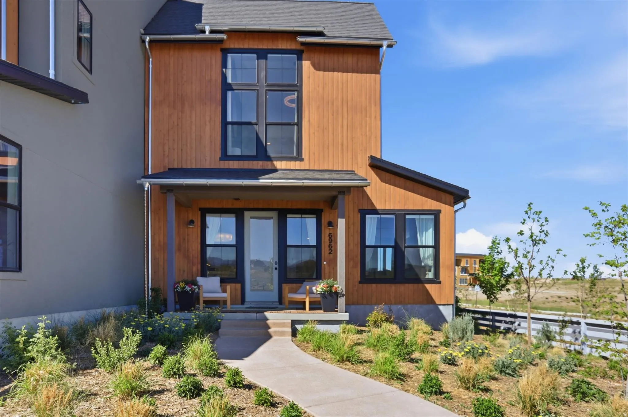 Modern architectural facade featuring wood-finish siding and dark trim windows