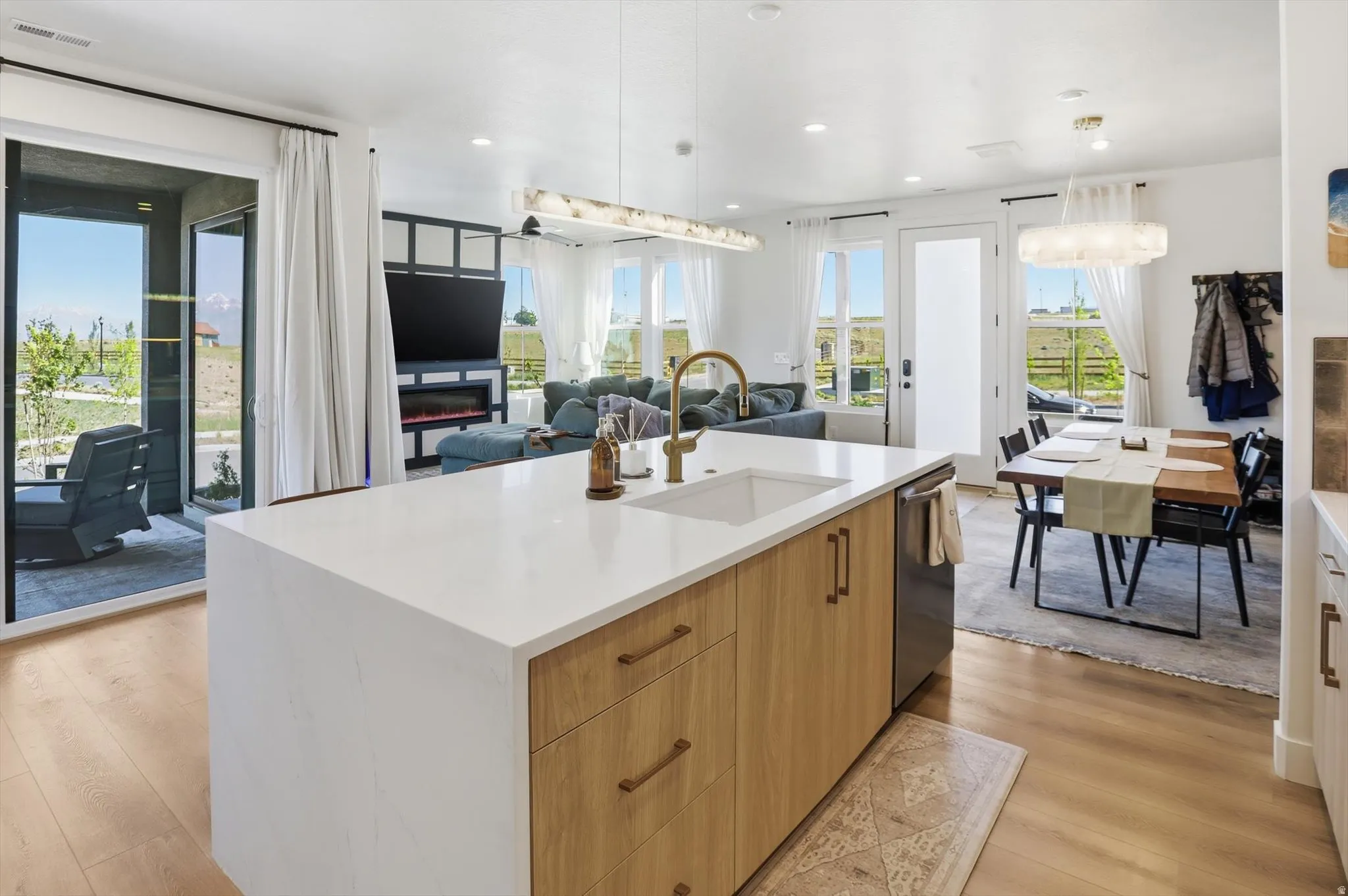Open-concept living area featuring a large kitchen island with a white countertop and wood-finish cabinetry