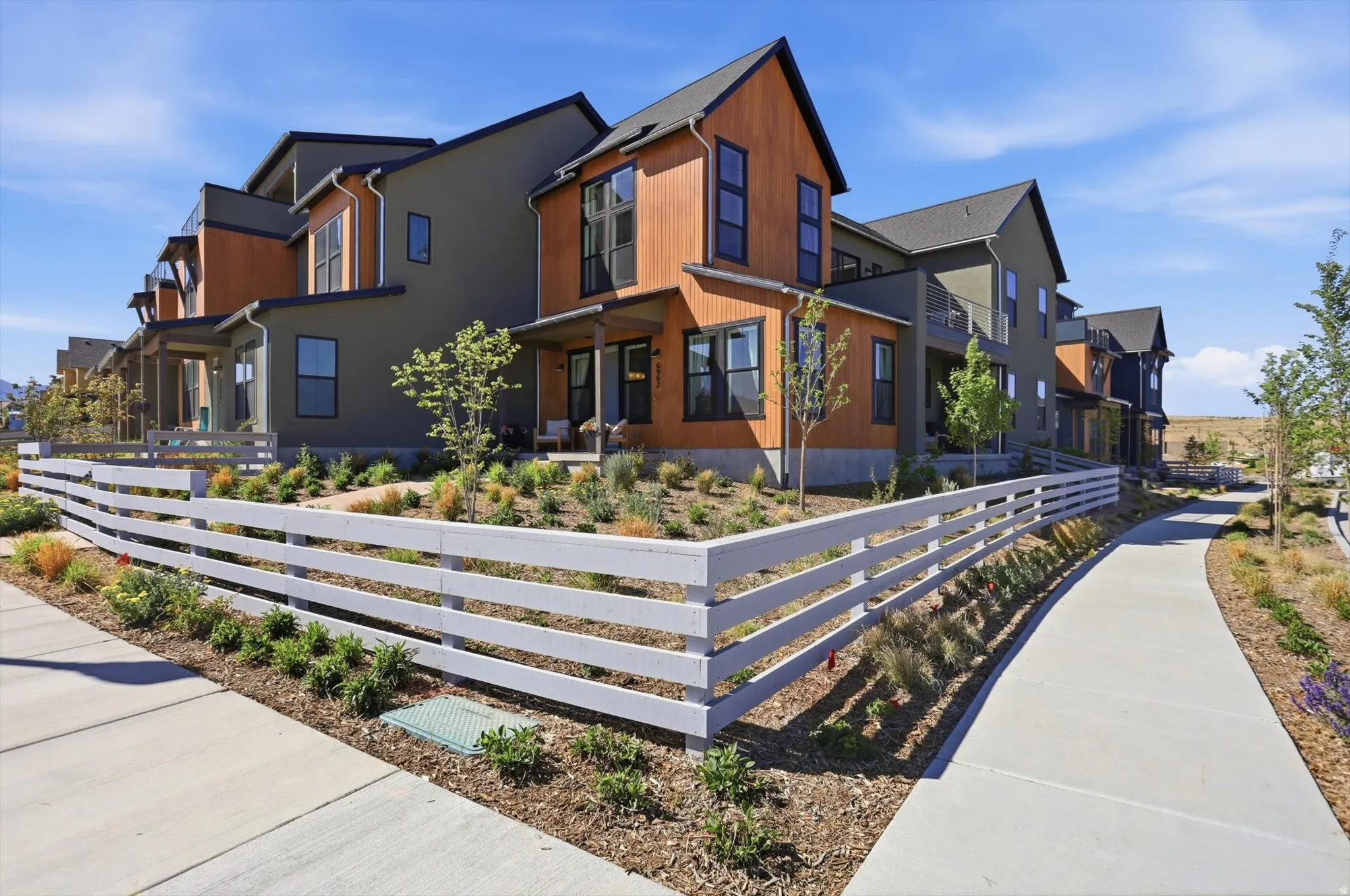 Contemporary multi-level residences featuring mixed-material facades with wood-look siding and dark-toned stucco