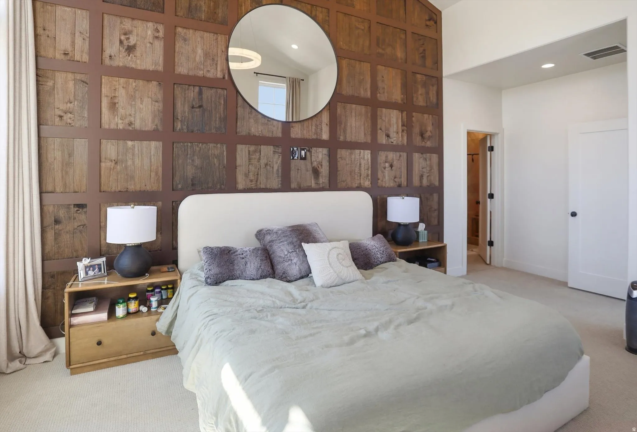 Feature wall with natural wood paneling and a large circular mirror