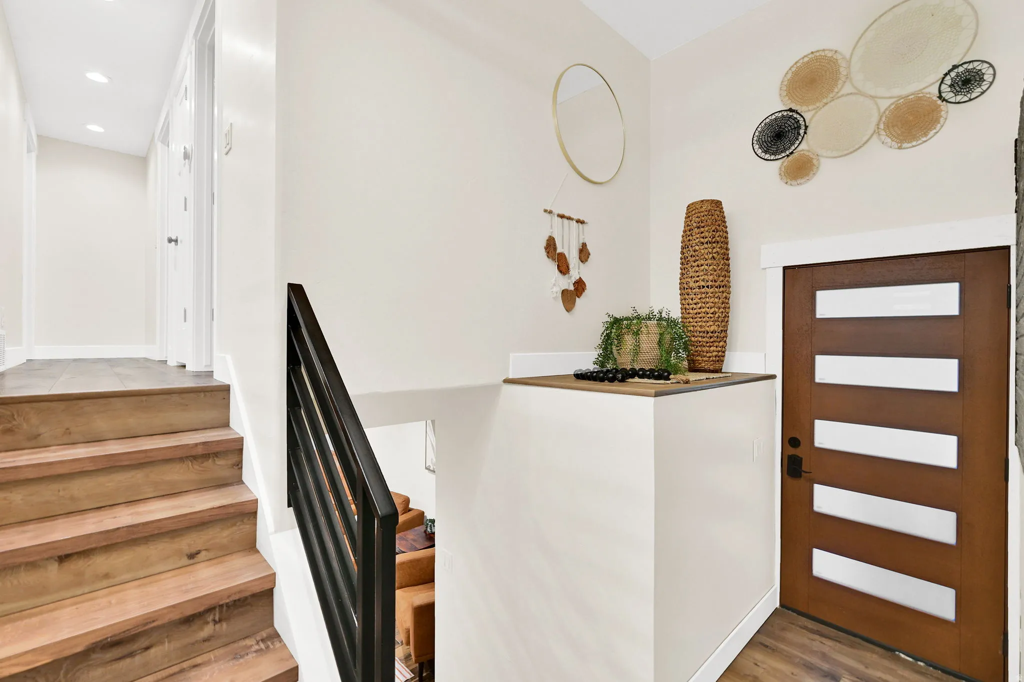 Warm wood-finish stair treads with a black metal handrail